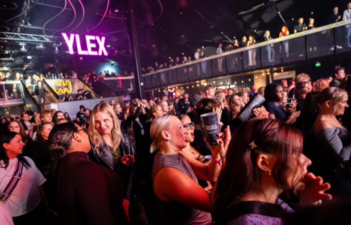 Yleisöä Tavara-aseman keikalla, taustalla hohtava YleX-logo