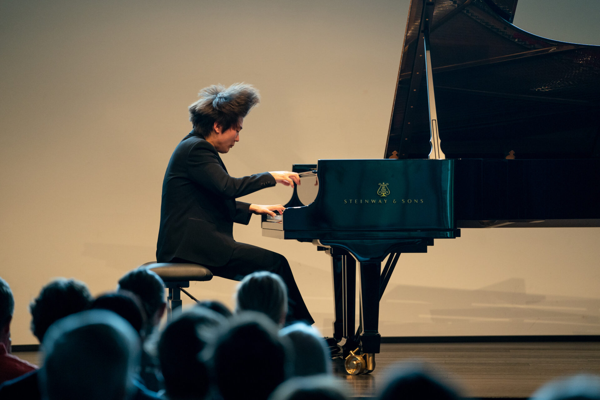 Pianisti Seong-Jin Cho esiintymässä Mäntän Musiikkijuhlilla. Pianisti näyttää soittavan vauhdikkaasti ja keskittyneesti, hänen hiuksensa ovat pysähtyneet ilmavirran mukana kuvanottohetkellä pystyyn.