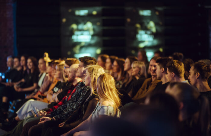 Yleisö istuu ja hymyilee Tampereen elokuvajuhlien tapahtumassa