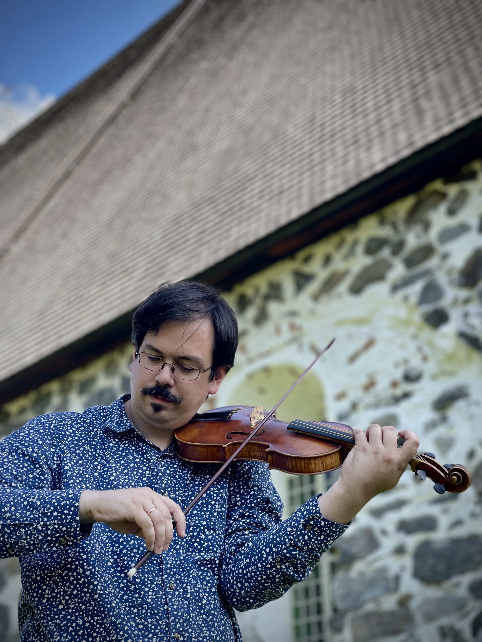 Anthony Marini soittaa viulua vanhan kirkkorakennuksen edessä.