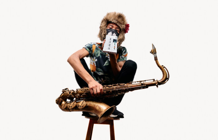 Tomoki Sanders kyykkyasennossa tuolin päällä.