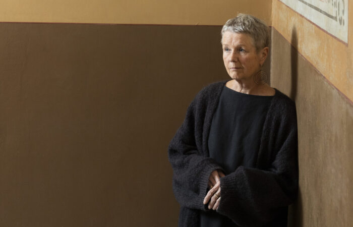 Leena Kumola nojaa kiviseinään.